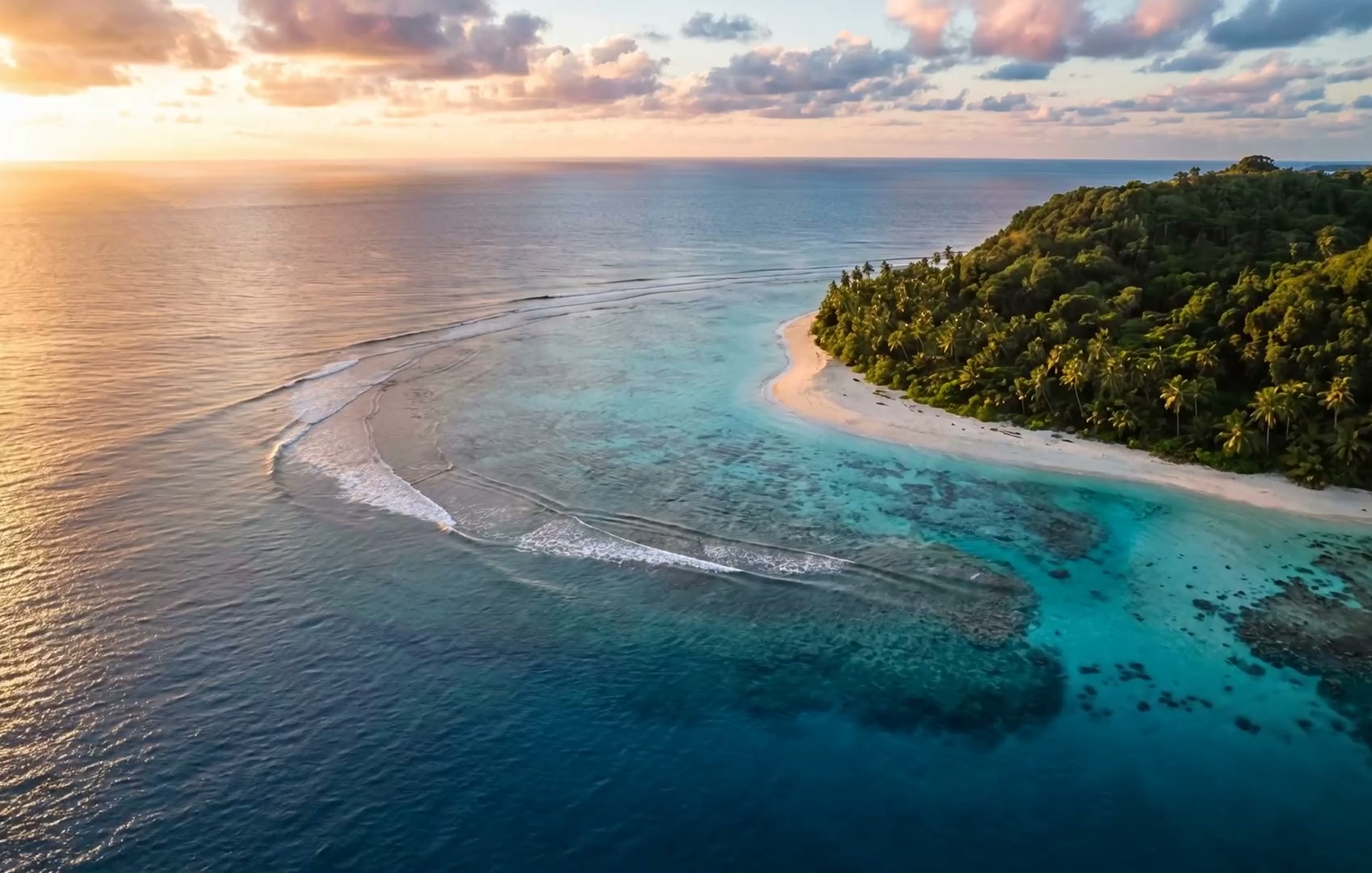 Aerial view of a tropical island coastline at golden hour